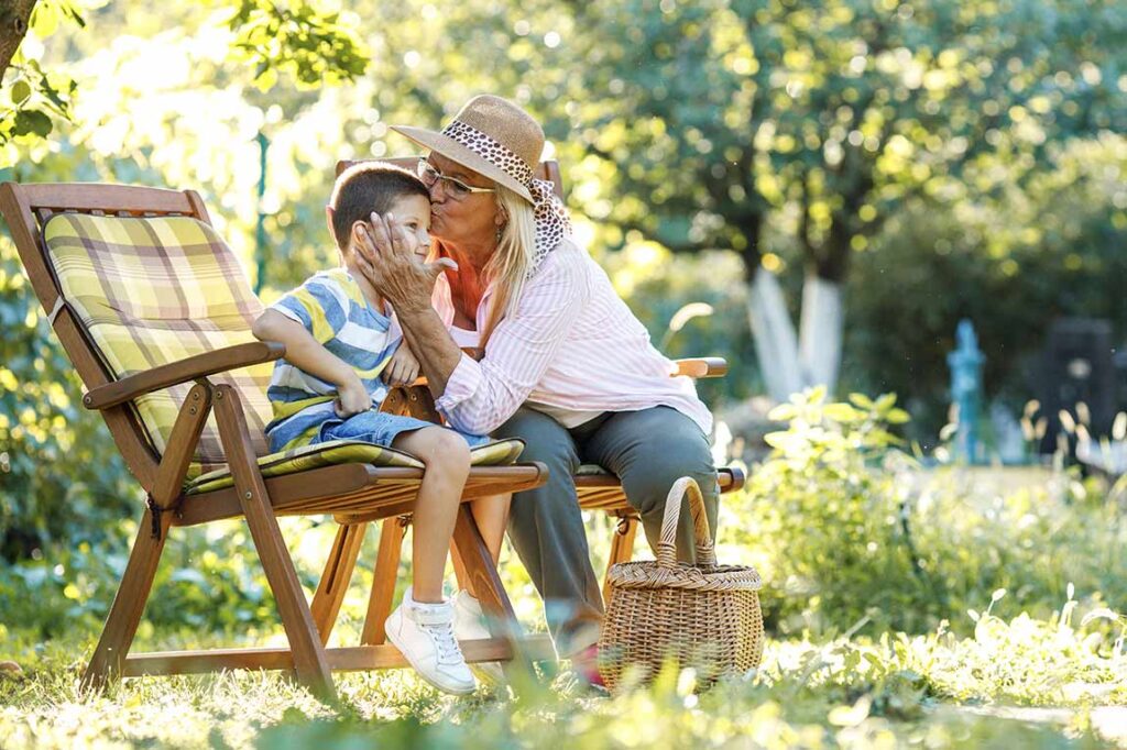 grandmother kissing her grandchilds face in the garden life insurance in retirement