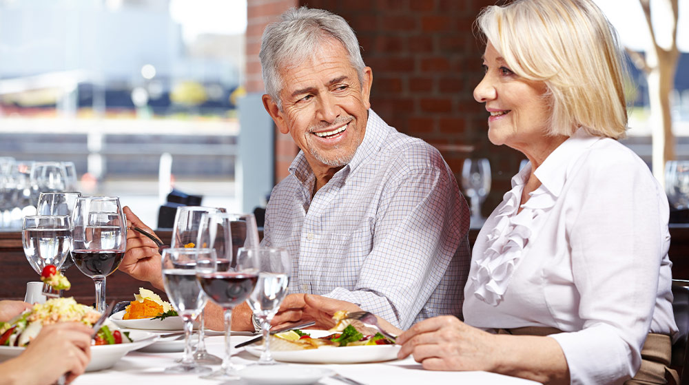 smiling couple at a restaurant for a complimentary dinner seminar do i have enough to retire